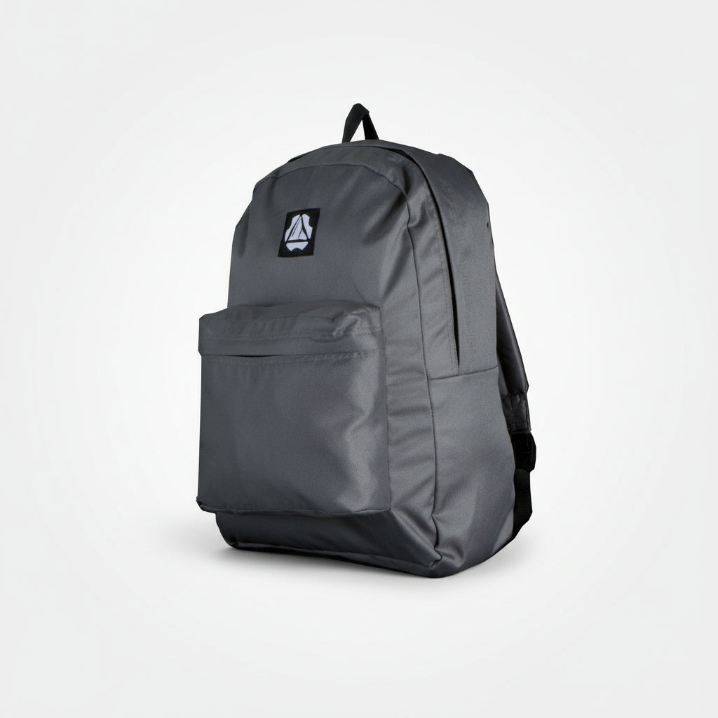 A grey Krevis Basic Backpack with a front zipper pocket and a padded shoulder strap, viewed from the front.